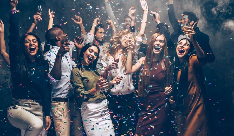 Christmas Party group of people celebrating with glitter in the air